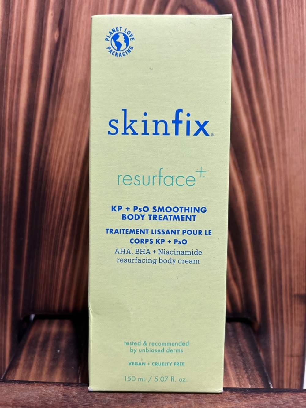 Skin resurfacing body cream in light green with blue logo